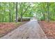Home with attached garage surrounded by mature trees, set back on a long driveway, providing a private and serene setting at 2288 Hudson Sw Dr, Lilburn, GA 30047