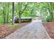 Beautiful home with attached garage surrounded by mature trees, set back on a long driveway, providing a private and serene setting at 2288 Hudson Sw Dr, Lilburn, GA 30047