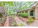 Inviting home exterior with brick facade, arched entryway, landscaped walkway, and mature trees at 2288 Hudson Sw Dr, Lilburn, GA 30047