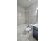Bathroom featuring shower-tub combo and single sink vanity with tiled floor and walls at 2514 Norwood Park Crossing, Doraville, GA 30340