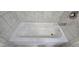 A white bathtub is surrounded by tiled walls and a showerhead faucet at 2514 Norwood Park Crossing, Doraville, GA 30340