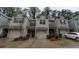 Townhouse with attached garages, brick accents, gray siding and well maintained landscaping on a cloudy day at 2514 Norwood Park Crossing, Doraville, GA 30340