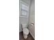 A view of a gray-walled half-bathroom with a toilet and a window at 2514 Norwood Park Crossing, Doraville, GA 30340
