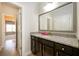 Bright bathroom featuring granite countertops, dark cabinets, and an open doorway to the hallway at 4041 Woodward Walk Ln, Suwanee, GA 30024
