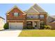 Beautiful brick two-story home with a well-manicured lawn and attached two car garage at 4041 Woodward Walk Ln, Suwanee, GA 30024