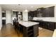Spacious kitchen features a large island, stainless steel appliances, and beautiful dark wood cabinetry at 4041 Woodward Walk Ln, Suwanee, GA 30024