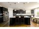 Modern kitchen with dark cabinetry, granite countertops, stainless steel appliances, and a center island at 4041 Woodward Walk Ln, Suwanee, GA 30024
