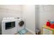 Functional laundry room with modern washer and dryer, wire shelving, and tile flooring at 4041 Woodward Walk Ln, Suwanee, GA 30024