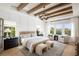 Luxurious main bedroom with exposed beam ceiling, french doors and scenic views at 5515 Misty Glen Ln, Cumming, GA 30040