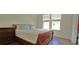 Comfortable bedroom with wood frame bed, matching nightstand, and a large window at 2962 Girard Ln, Duluth, GA 30097
