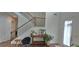 Welcoming entryway with wooden staircase, console table with plants, and modern chair at 2962 Girard Ln, Duluth, GA 30097
