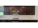 Well-equipped kitchen featuring quartz countertops, stainless steel microwave, and dark brown cabinetry at 2962 Girard Ln, Duluth, GA 30097