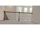 View of the landing with wooden rails and iron spindles, leading to carpeted stairs and filled with natural light from surrounding windows at 2962 Girard Ln, Duluth, GA 30097
