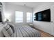 This bedroom features light colored walls, wood flooring, two windows, and a large television at 4856 Allatoona Gtwy # 8, Acworth, GA 30101