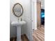 A stylish powder room with a pedestal sink, wood accent wall, and elegant mirror at 4856 Allatoona Gtwy # 8, Acworth, GA 30101