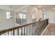 Bright hallway featuring wrought iron railing, chandelier, and neutral walls at 512 Dolce Rd, Locust Grove, GA 30248