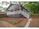 Side view of a gray home showing a porch with white railing and landscape with an ADT security sign at 1889 Vesta Ave, Atlanta, GA 30344