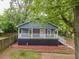 Charming gray house with a cozy front porch and neat landscaping, surrounded by mature trees at 1889 Vesta Ave, Atlanta, GA 30344