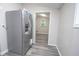 Hallway featuring a stainless steel refrigerator and matching gray wood-look floors at 1889 Vesta Ave, Atlanta, GA 30344