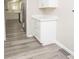 Hallway featuring matching gray floors, a storage cabinet and views of the kitchen area at 1889 Vesta Ave, Atlanta, GA 30344