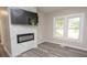 Bright living room featuring a modern fireplace, stylish gray flooring, and natural light from the windows at 1889 Vesta Ave, Atlanta, GA 30344