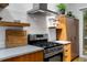 Close up of kitchen with gas range, floating shelves and stainless steel exhaust at 318 5Th Ne St, Atlanta, GA 30308