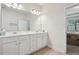 Bright bathroom features a double sink vanity, a large mirror, and a doorway to an adjacent room at 3382 Long Creek Dr, Buford, GA 30519