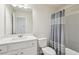 Bright bathroom featuring a vanity with white cabinets and a shower with a gray and white striped curtain at 3382 Long Creek Dr, Buford, GA 30519