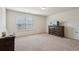 Calm and spacious bedroom with a large window, dresser, television, and neutral tones for a peaceful retreat at 3382 Long Creek Dr, Buford, GA 30519