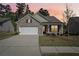 Charming single-story brick home with a two-car garage, well-kept lawn against the colors of the sunset at 3382 Long Creek Dr, Buford, GA 30519