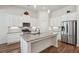Modern kitchen features white cabinets, granite countertops, stainless steel appliances, and a large center island at 3382 Long Creek Dr, Buford, GA 30519