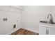 Functional laundry room with utility sink, storage cabinet, and hookups for laundry machines at 3382 Long Creek Dr, Buford, GA 30519