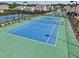 Aerial view of a blue and green outdoor tennis court with surrounding trees, benches and fencing, a great amenity at 3382 Long Creek Dr, Buford, GA 30519