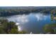 An aerial view showing lake surrounded by lush forest trees in a neighborhood at 8399 Lake Dr, Snellville, GA 30039