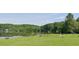 Open lawn with lake, benches, picnic tables, playground, and surrounding greenery at 8399 Lake Dr, Snellville, GA 30039