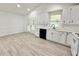 A bright kitchen featuring stainless steel appliances, white cabinets, and an adjacent dining space at 8399 Lake Dr, Snellville, GA 30039