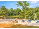 Sandy beach area next to the lake with picnic tables, umbrellas, and playground equipment at 8399 Lake Dr, Snellville, GA 30039