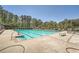 Community swimming pool with clear water, lounge chairs, and surrounding greenery at 8399 Lake Dr, Snellville, GA 30039