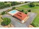 Overhead view of community pool, with a building and parking, surrounded by lush greenery and roads at 13 Four Feathers Ln, Rydal, GA 30171