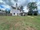 Large grassy backyard enclosed by a wooden fence with view of home's rear at 13 Four Feathers Ln, Rydal, GA 30171