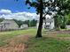 Wide open backyard with a playground, mature trees, and a partial fence at 13 Four Feathers Ln, Rydal, GA 30171