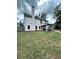 View of the backyard with covered patio, tall chimney, and partial fence at 13 Four Feathers Ln, Rydal, GA 30171