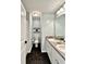 This bathroom includes dual sinks, black vinyl floor, modern light fixture, and walk-in shower at 13 Four Feathers Ln, Rydal, GA 30171