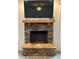 A stone fireplace with a wooden mantle, a flatscreen TV and tile flooring at 13 Four Feathers Ln, Rydal, GA 30171