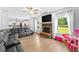 Bright living room features a stone fireplace, large windows, and an open layout leading into the kitchen at 13 Four Feathers Ln, Rydal, GA 30171