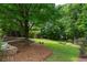Private backyard with lush landscaping, stone seating area, and mature trees creating a serene outdoor space at 3212 Arden Nw Rd, Atlanta, GA 30305