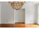 Bright living room showcasing gleaming hardwood floors, large chandelier and entry to next room at 3212 Arden Nw Rd, Atlanta, GA 30305