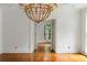 Bright living room showcasing gleaming hardwood floors, large chandelier and entry to next room at 3212 Arden Nw Rd, Atlanta, GA 30305