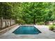 Backyard pool with stone patio, lush trees, and privacy fencing at 3212 Arden Nw Rd, Atlanta, GA 30305
