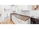 Well-lit kitchen featuring white cabinets, stainless steel sink, and laundry area, offering functionality and style at 37 Winesap Ct, Temple, GA 30179